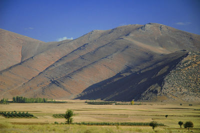 Scenic view of field and mountains against sky