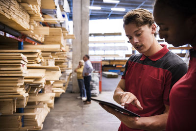 Salesman explaining female staff over digital tablet at hardware store