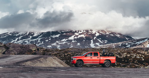 Car on snowcapped mountains against sky