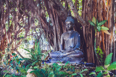 Statue amidst trees in forest