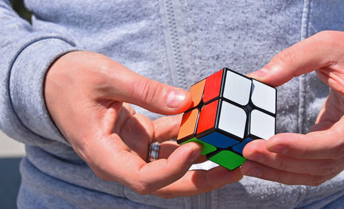 Midsection of man holding puzzle cube