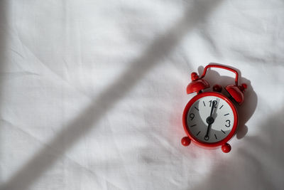 High angle view of alarm clock on bed