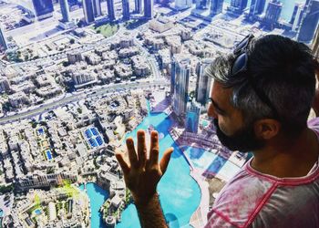 Close-up of man with cityscape in background