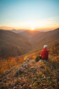 Brave adventurer sits on a rock during sunset in the area of mojtin in strazov mountains in slovakia