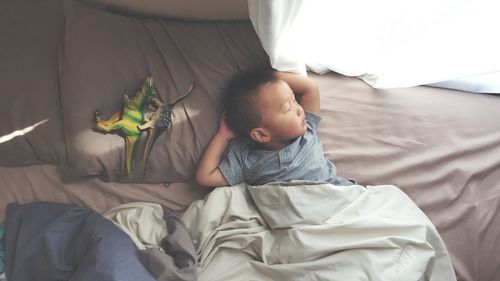 High angle view of boy sleeping on bed