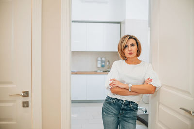 Close-up portrait of a beautiful slim woman in the doorway of a bright medical office. mock-up