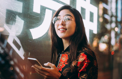 Portrait of young woman using mobile phone