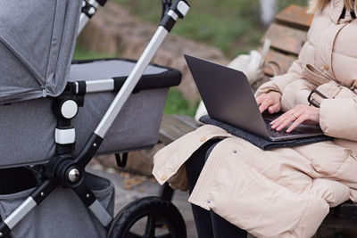 Midsection of woman using laptop outdoors