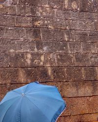 Blue umbrella against wall