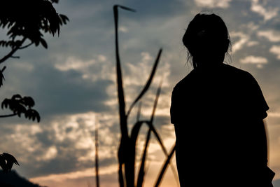 Silhouette woman standing against sky during sunset