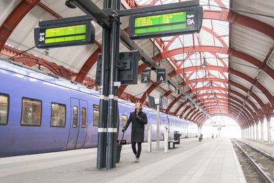 Man checking timetable at train station