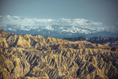 Scenic view of land and mountains against sky