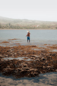 Man standing on beach against sky