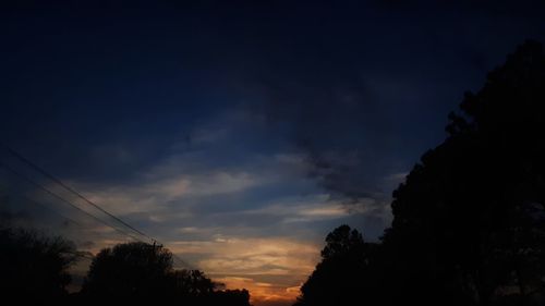 Low angle view of silhouette trees against sky at sunset