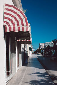 Built structure by street against clear blue sky