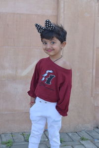 Portrait of boy standing against wall