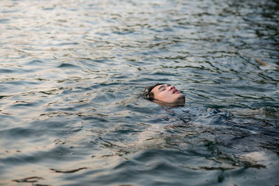 High angle portrait of woman lying in water