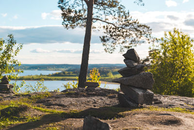 Stack of rocks by trees against sky