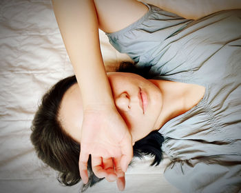 Image of woman lying on bed looking tired