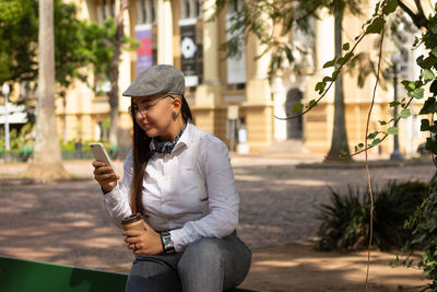 Young man using mobile phone while standing outdoors