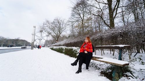 Rear view of woman on snow covered trees during winter