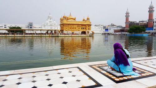 Rear view of woman at temple against sky