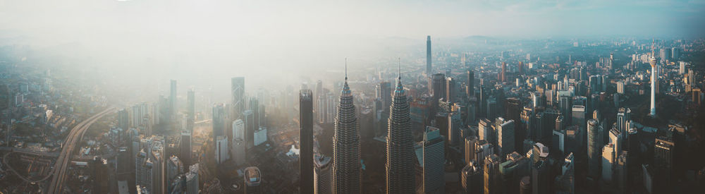 Panoramic view of modern buildings in city against sky