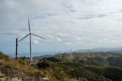 Wind turbines on land against sky