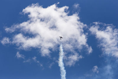 Low angle view of airplane flying against blue sky