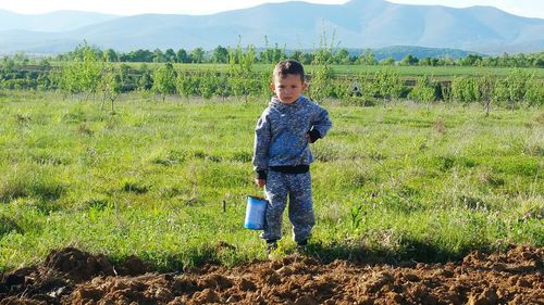 Rear view of boy standing on field