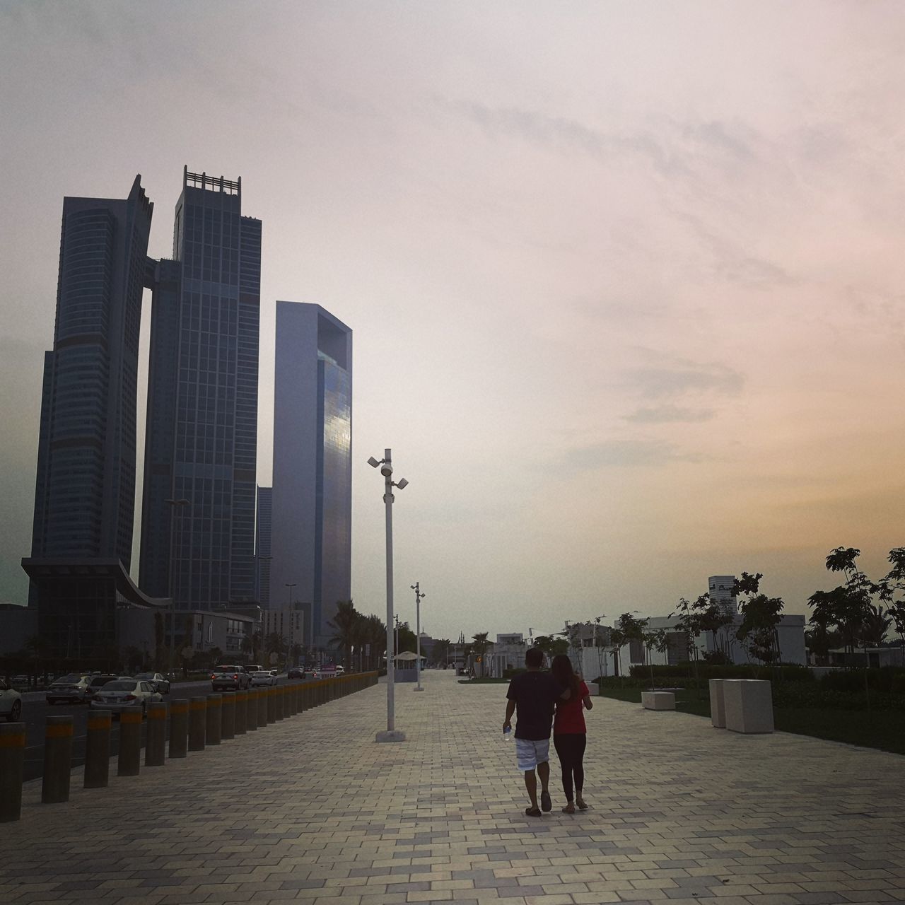 PEOPLE WALKING ON STREET AMIDST BUILDINGS IN CITY