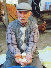 Portrait of mature man holding garlic at market