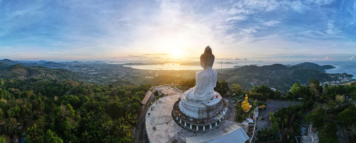 Statue of buddha against mountain and sky