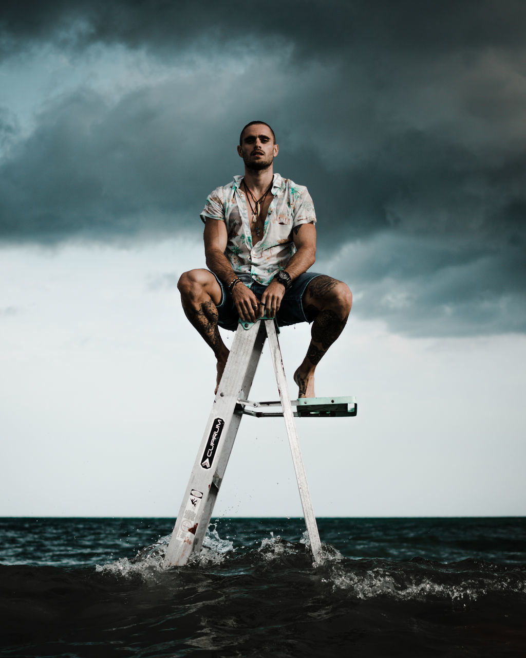 adult, cloud, one person, sky, water, full length, sea, men, nature, sitting, sports, young adult, overcast, copy space, storm, ocean, person, land, ladder, strength, outdoors, storm cloud, horizon over water, horizon, blue, holding, motion, surfing