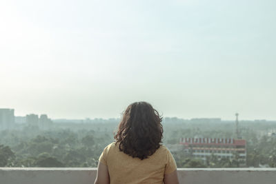 Rear view of woman looking at cityscape 