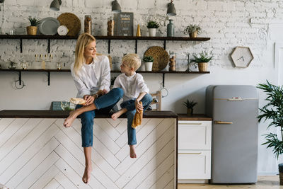 Full length of woman with arms raised at home