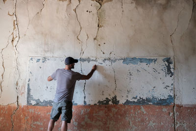 Young man standing against wall