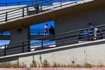 Low angle view of people working on bridge