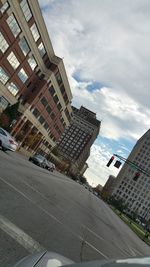 Buildings in city against cloudy sky