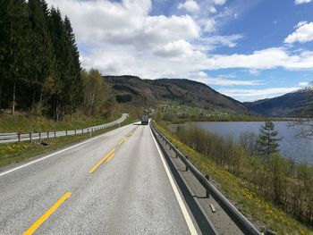 Road by mountains against sky