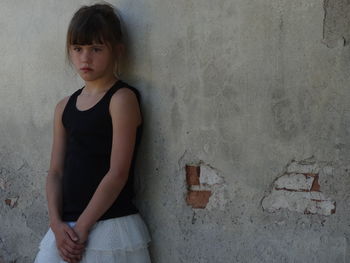 Young woman standing against wall