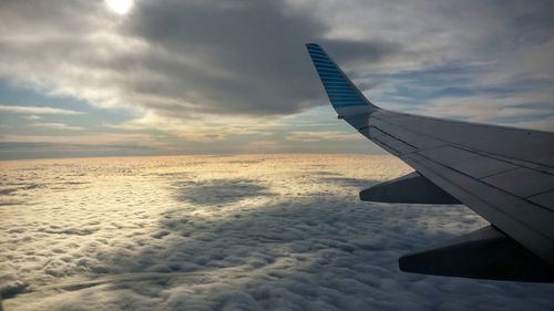 Cropped image of airplane against cloudy sky