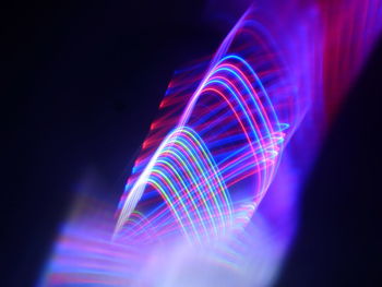 Illuminated light trails against black background