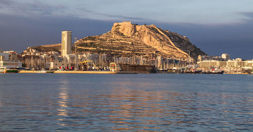 View of city by sea against sky