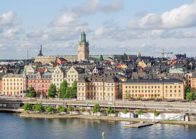 Buildings in city against cloudy sky