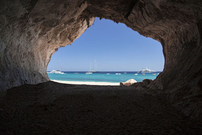 Scenic view of sea against clear sky seen through cave