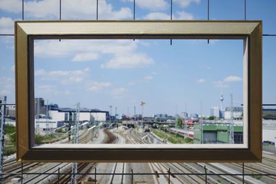 High angle view of railroad tracks against sky seen through window