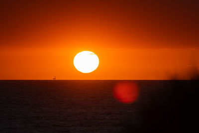 Scenic view of sea against orange sky