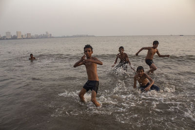 People enjoying on beach against sky