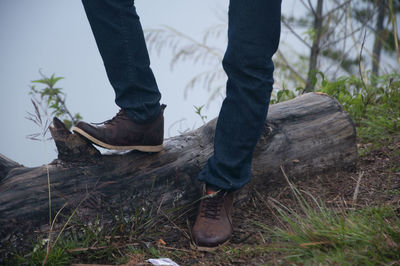Low section of man standing by lake